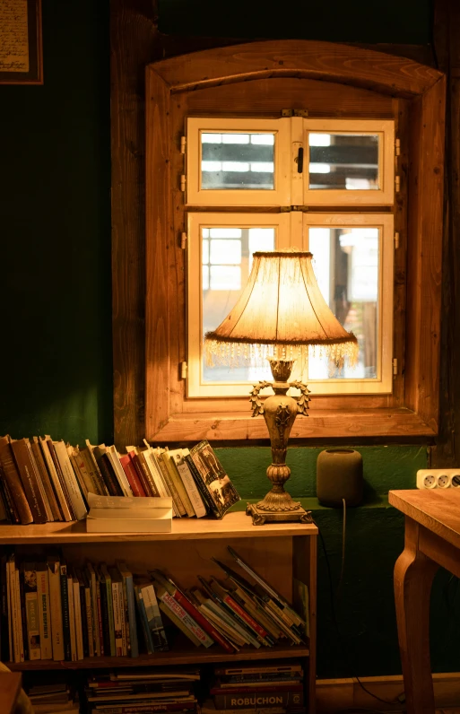 a table with a lamp sitting next to a window in a green room