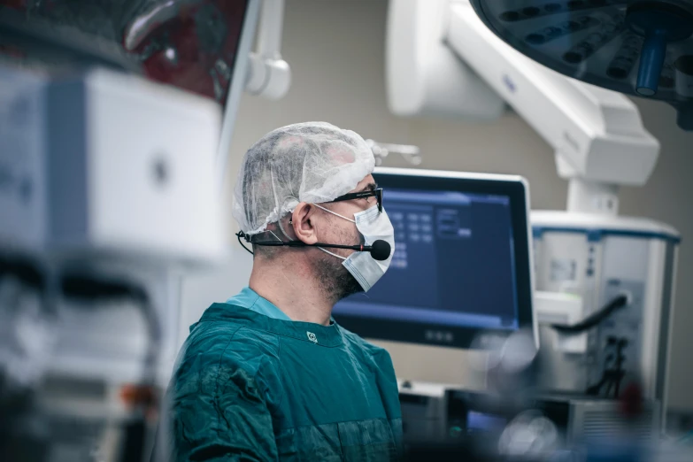 a doctor is looking at the monitor while in a hospital room