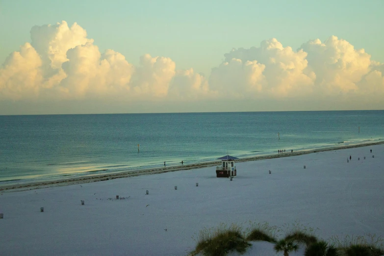 people are walking around on the beach near the ocean