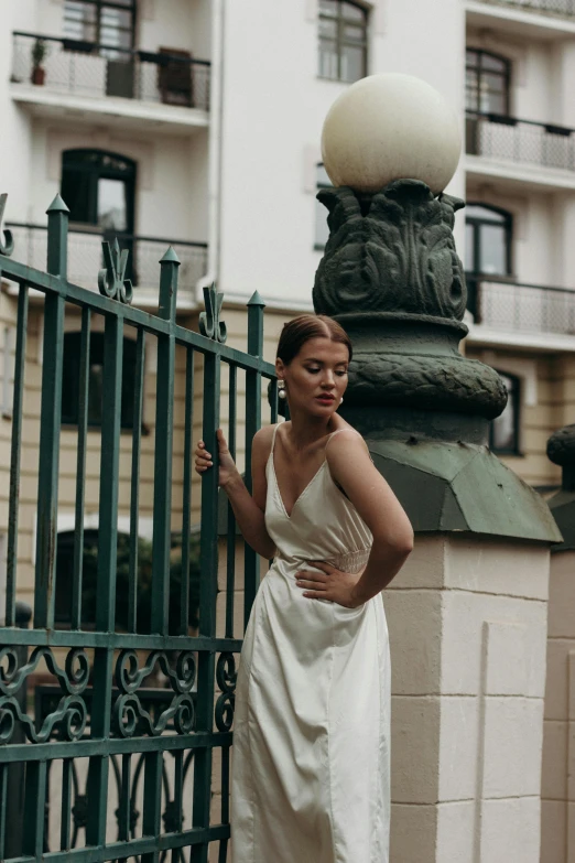 a woman is leaning on a green fence