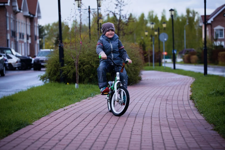 a  riding a green bike on the sidewalk