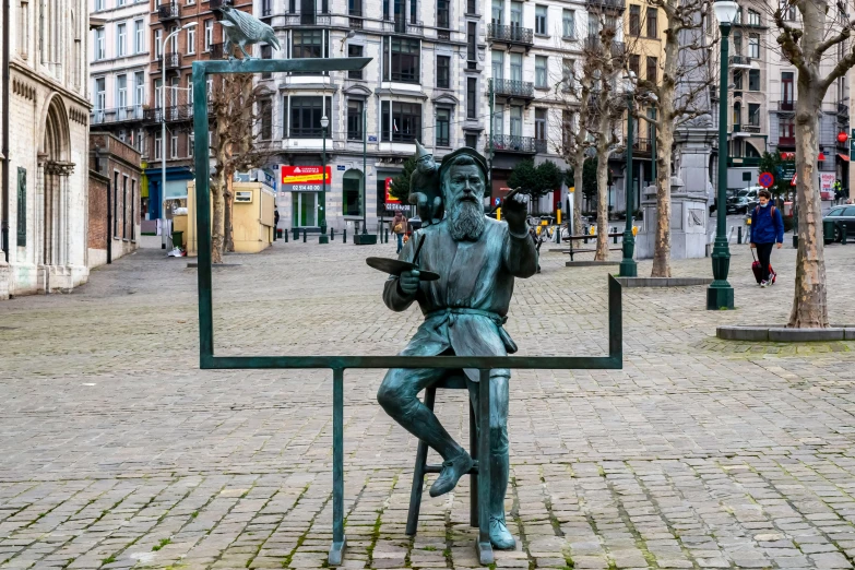 a statue is sitting on a small metal sign