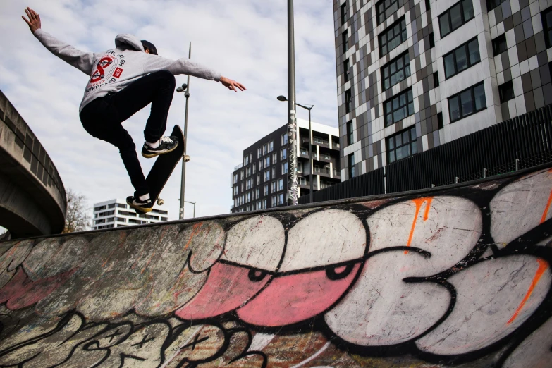 a young man riding a skateboard up the side of a concrete ramp