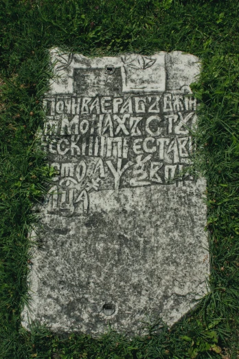 an old white stone marker with writing on it