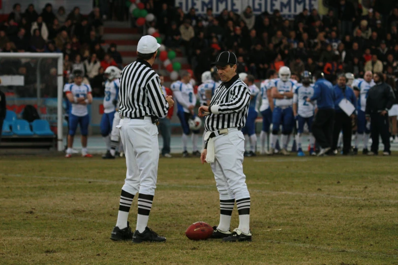 two professional referees are watching on the field