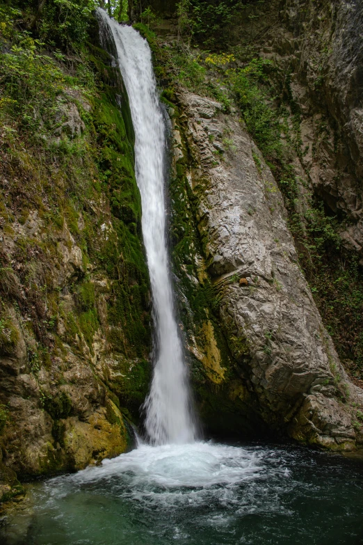 a tall waterfall on the side of a rocky cliff