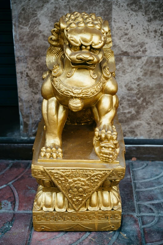 a golden statue on a red tile walkway