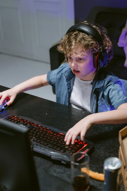 a boy with headphones on and a keyboard next to him