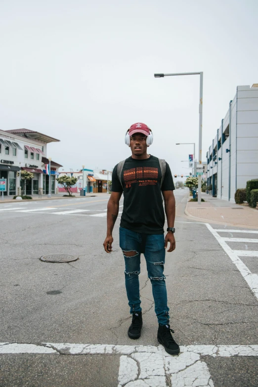 a man in ripped jeans standing by the street