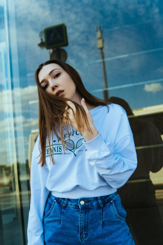 young woman standing in front of store with her hair blowing