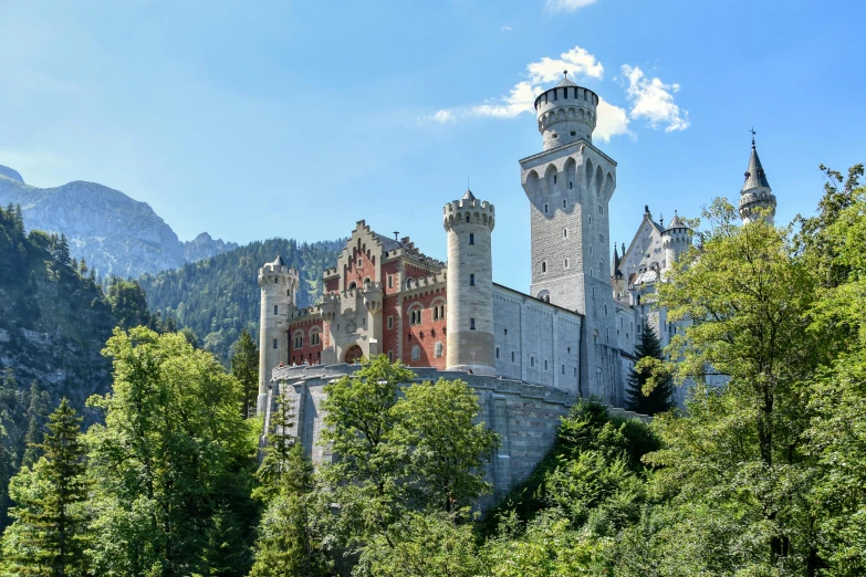 a castle that is on a hill behind trees