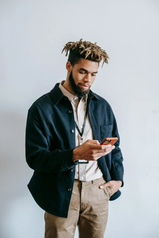 man in light colored pants holding phone and staring at it