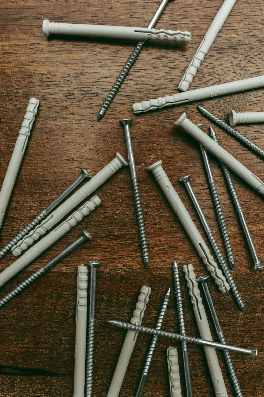 a group of screws laying on top of a wooden table