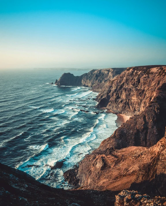 a view of the ocean with a large cliff