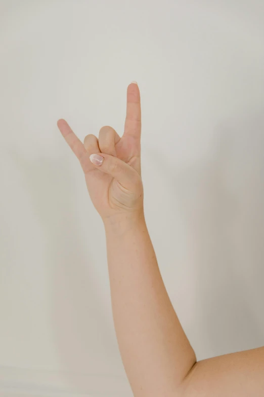 a woman with pink nail polish on her fingers and a peace sign