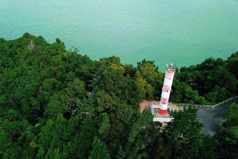 an aerial s of a lighthouse surrounded by green trees