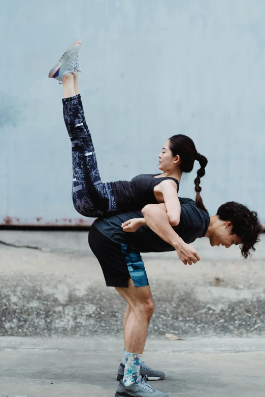 woman on top of another doing yoga on their feet