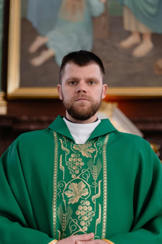 the priest poses in front of the painting