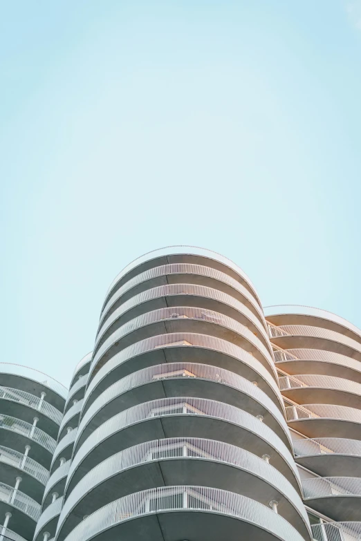 a very tall building with many balconies and an air plane flying in the background