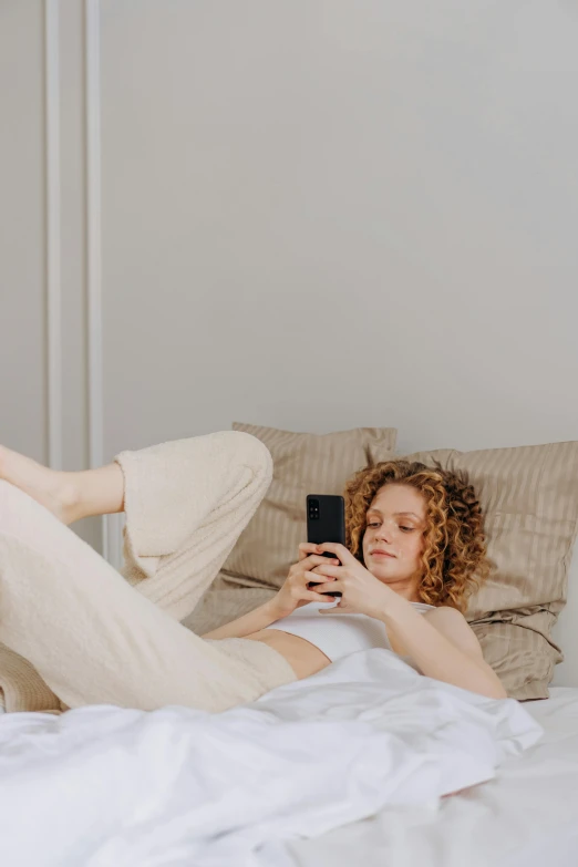 a person laying in bed with a phone