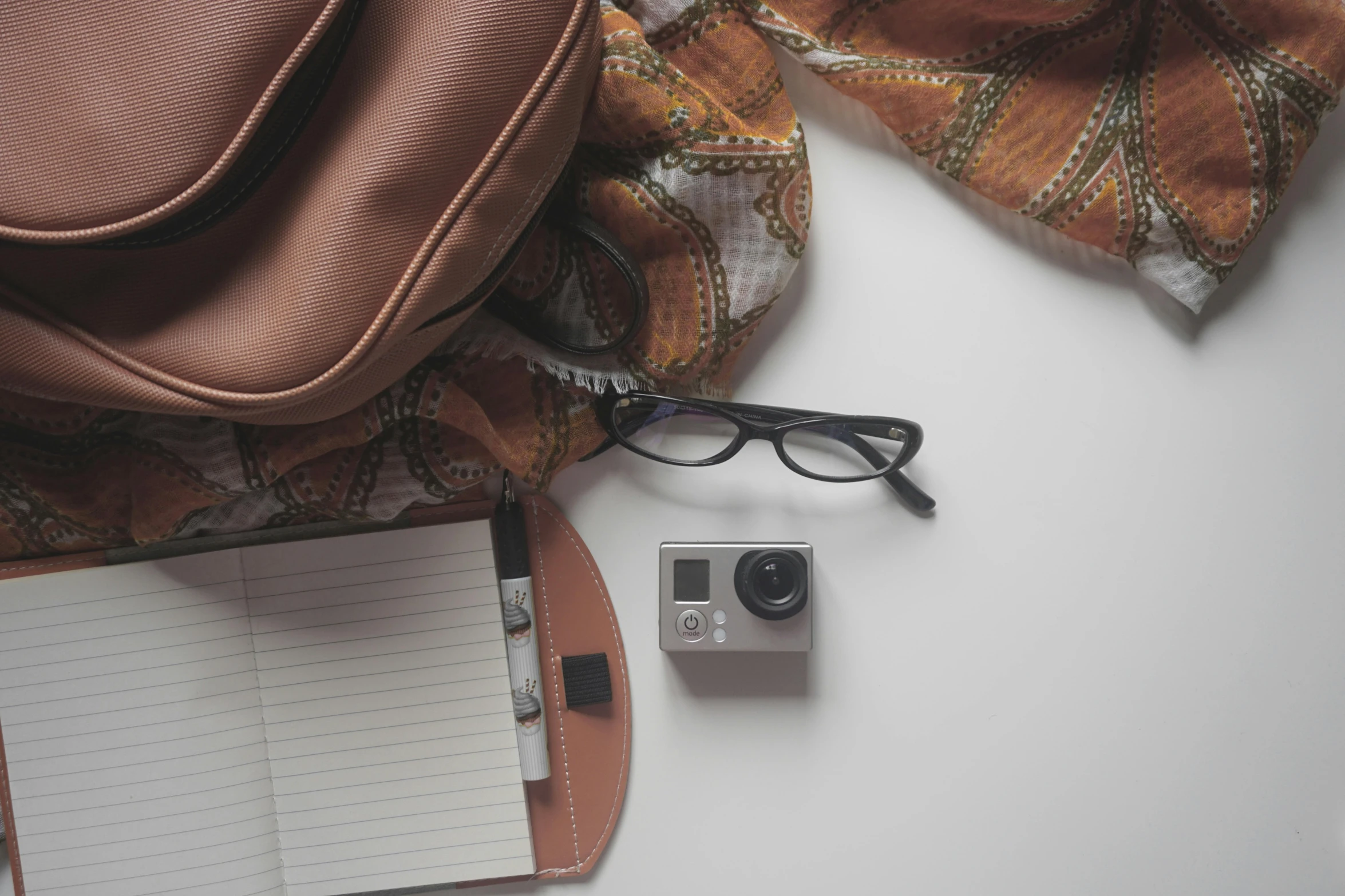 a backpack and a pair of glasses are arranged on a desk