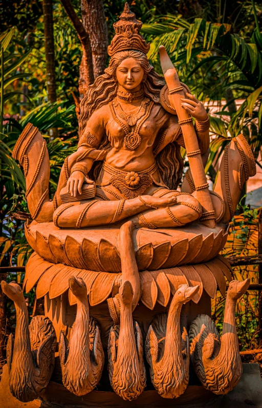 a statue of an ancient indian siting on a pile of wood