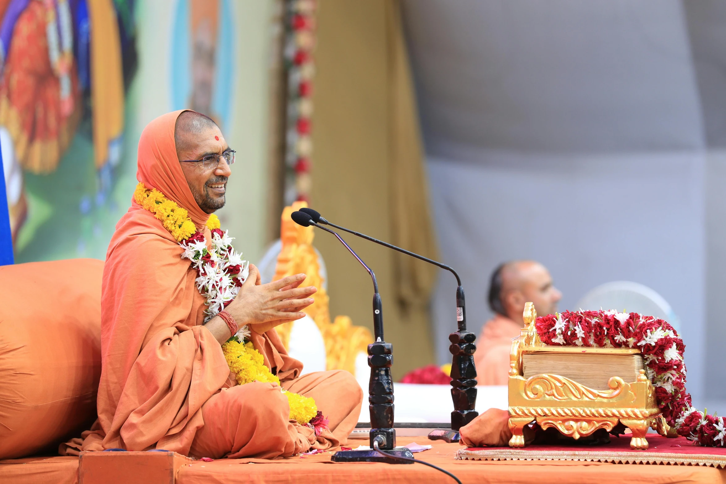 a man sitting next to a microphone near other people