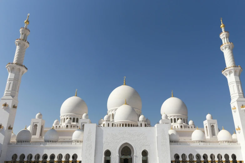 white building with yellow and white clocks and pillars