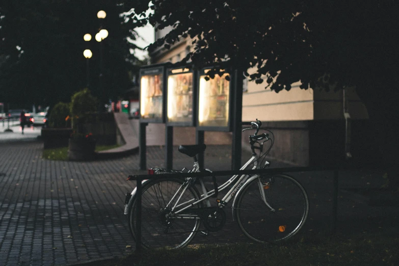 a bicycle leaning against a pole on the sidewalk