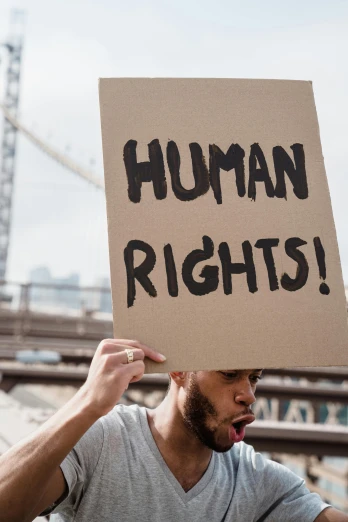 man holding up a sign reading human rights