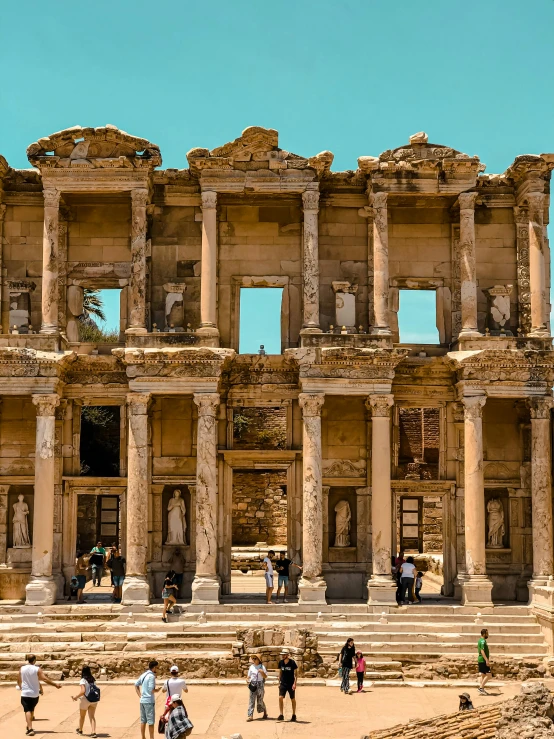 several people walk in front of an ancient building