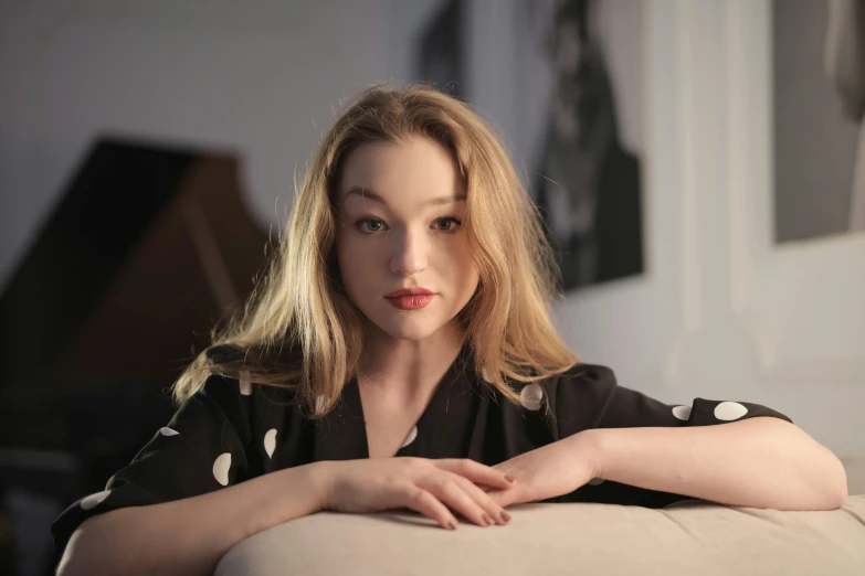 a woman with short blonde hair sitting on a couch