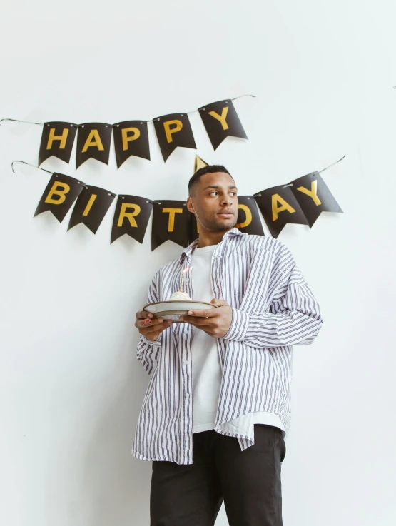 man posing with his birthday cake and balloons