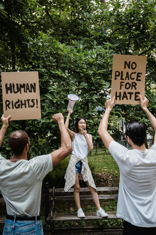 three people are holding signs in the air