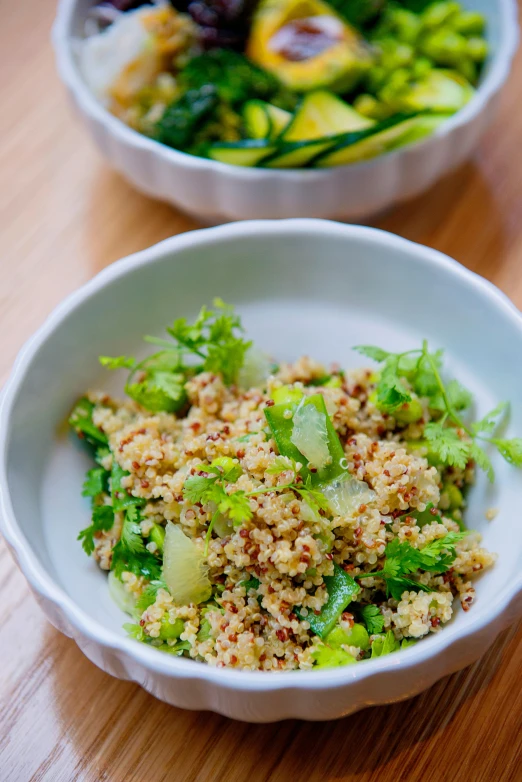 a bowl filled with food next to a bowl filled with salad