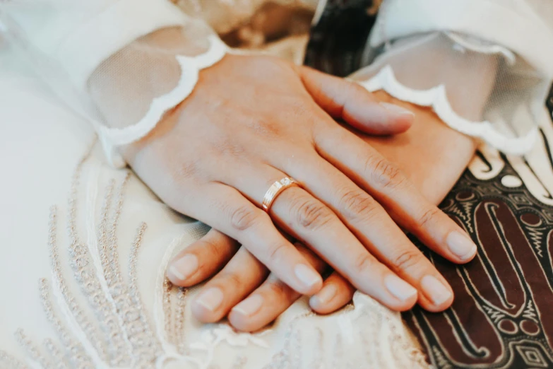 a couple holds each other's hand in their wedding dress