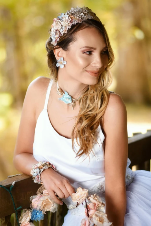 woman wearing necklace and dress sitting on wooden bench