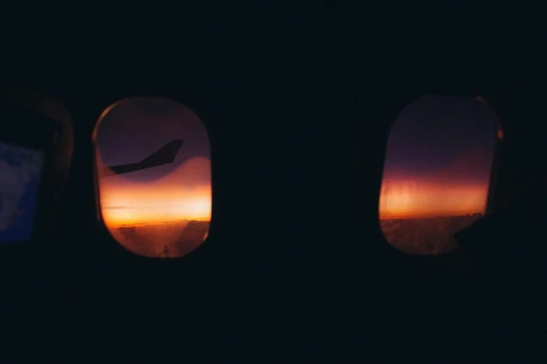 an airplane window with a view of the sunset