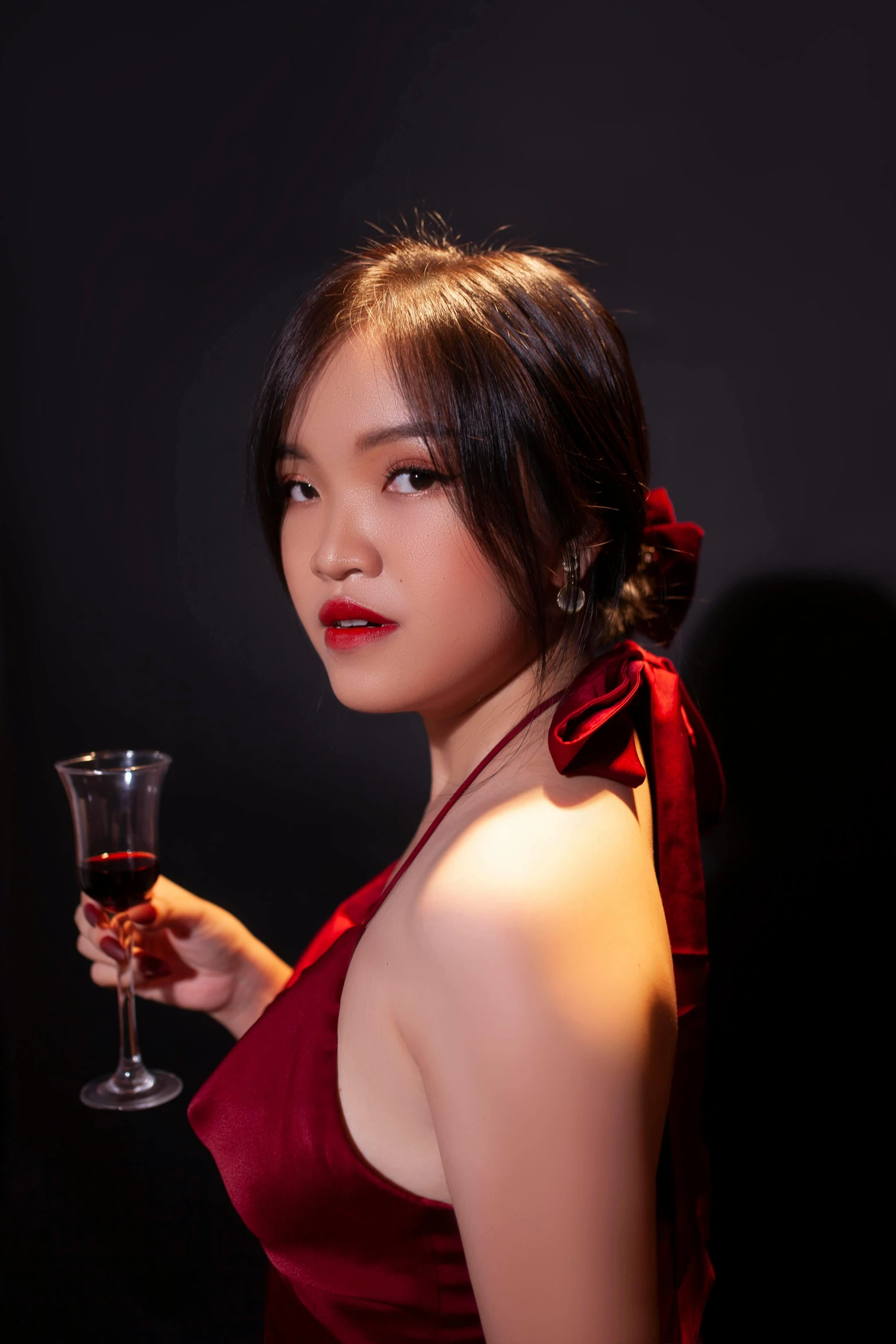 a woman dressed in red is holding a wine glass