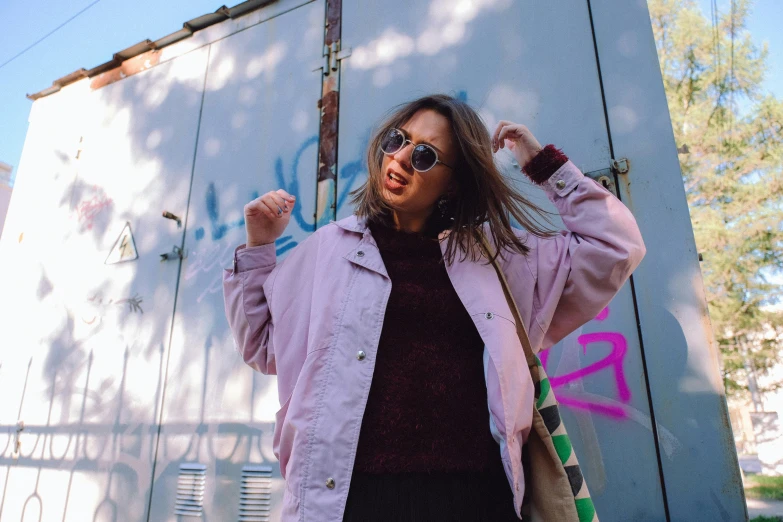 a woman in sunglasses with her hands in the air