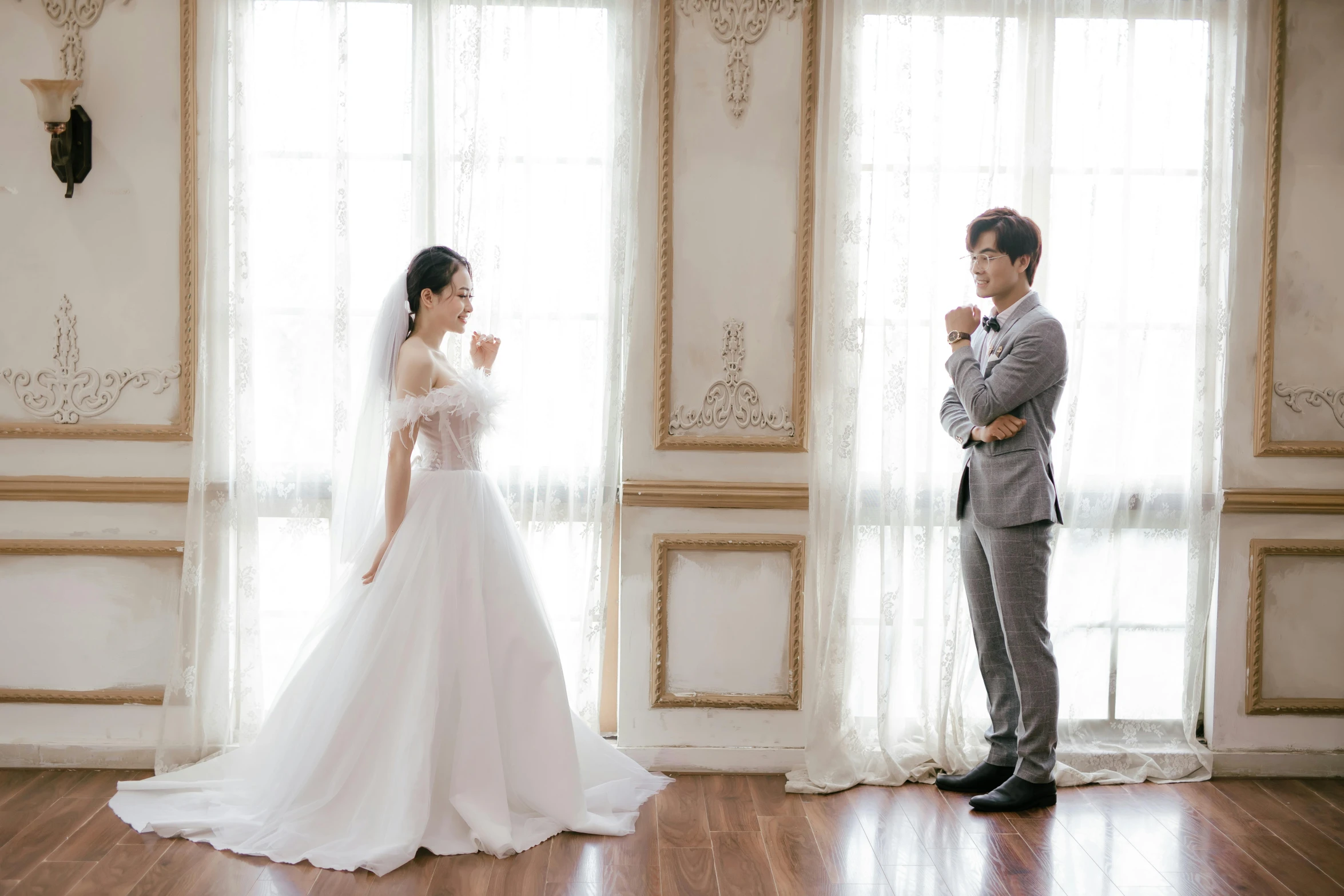 a couple posing for pictures in front of windows on their wedding day