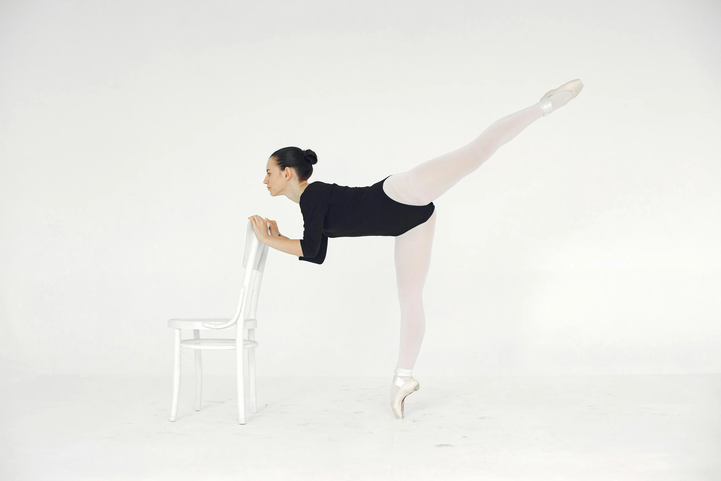 a ballet performs a stunt in front of a chair