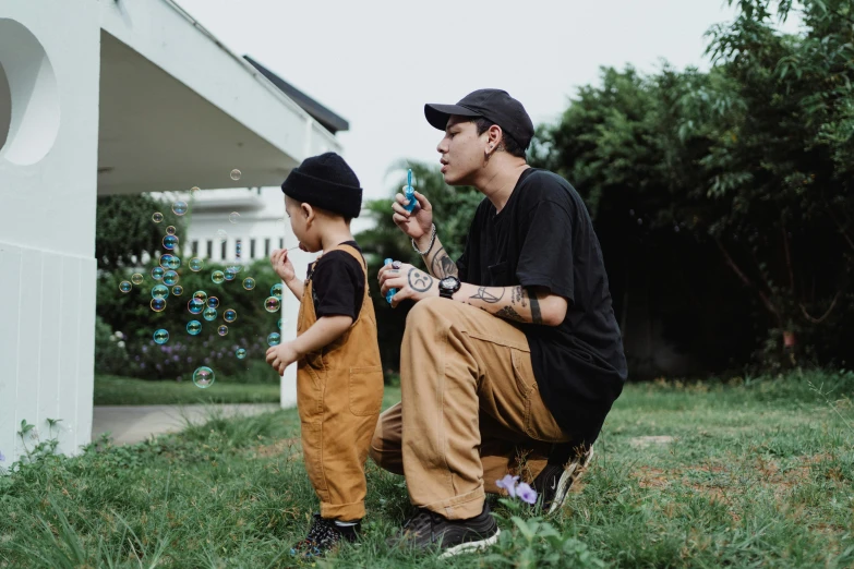 a man kneeling down in front of two s on the grass