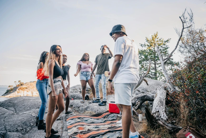 a group of young people standing on rocks and looking at soing in the distance