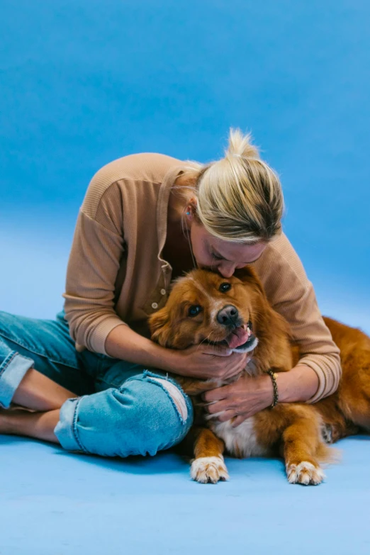 a woman is petting her dog on the floor