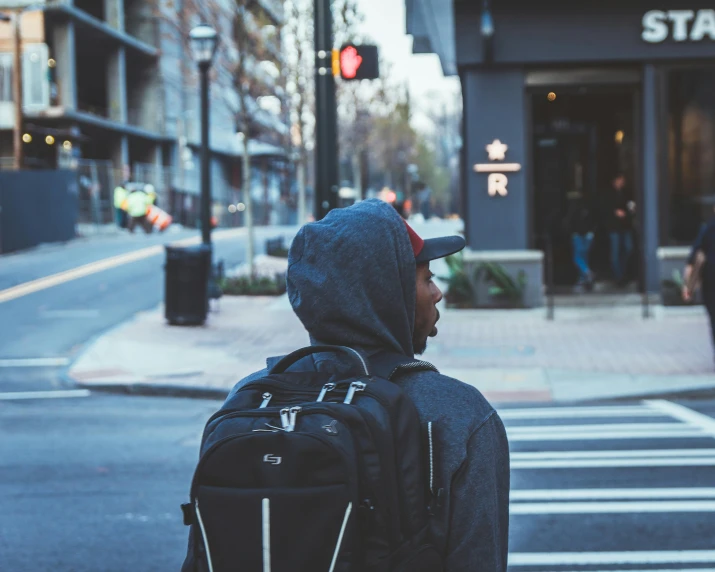 a man that is walking down the street with a backpack