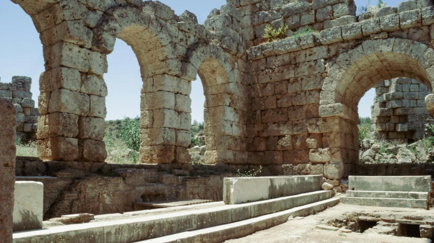 a group of stone archways built into a rock wall