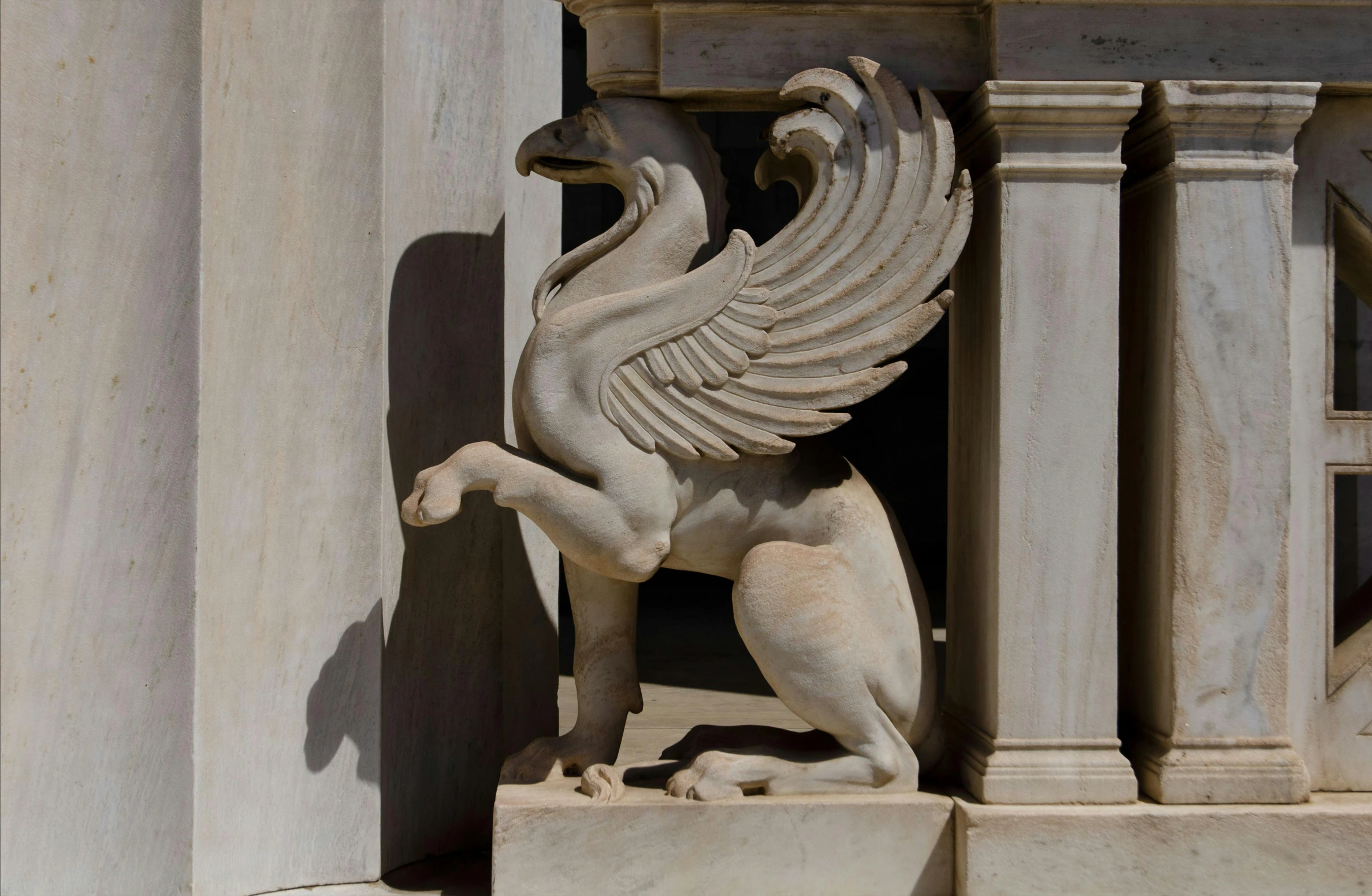 a statue with an animal in its paws and wings