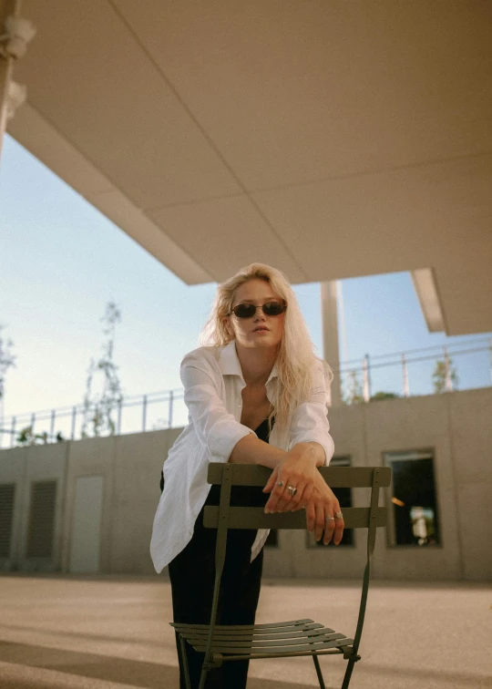 a woman with sunglasses is sitting on a bench