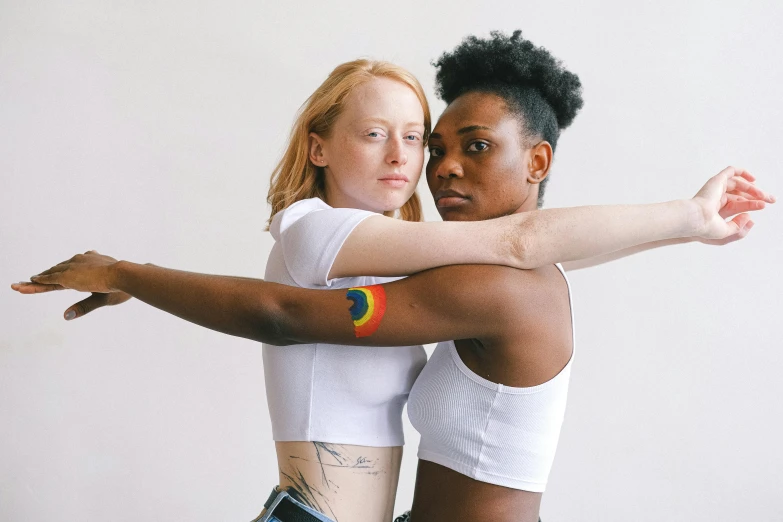 two girls pose for the camera and hold one another